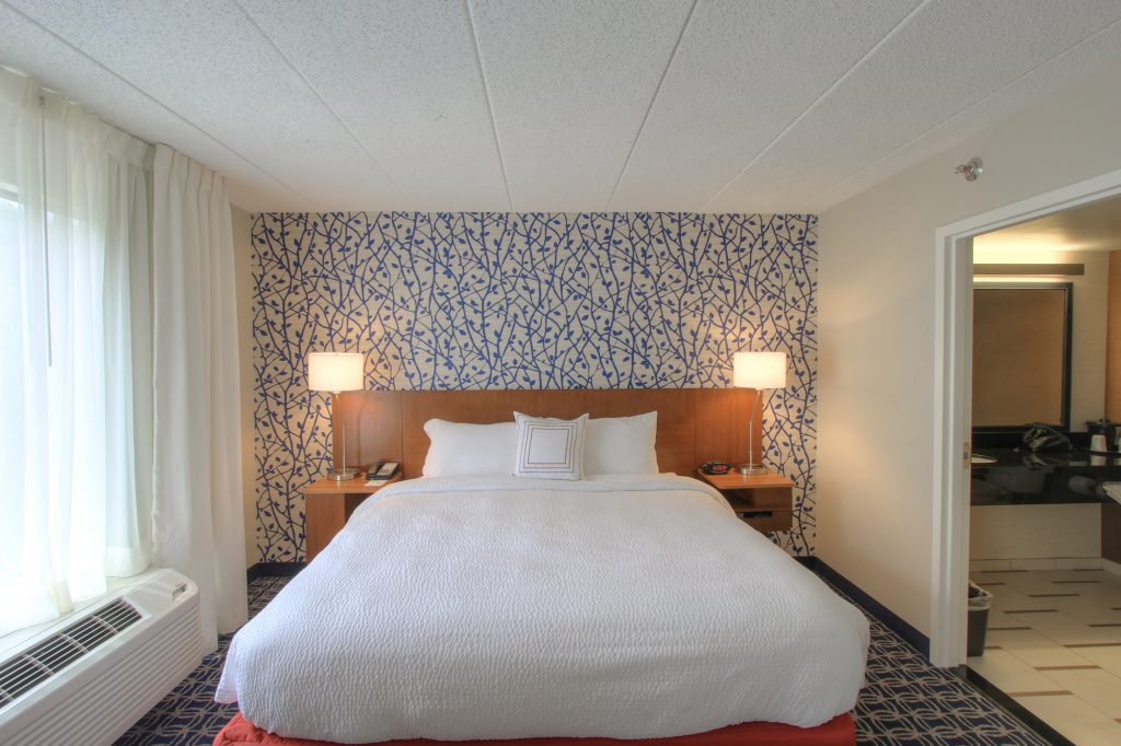 Hotel Room with wooden accents and blue leaf wallpaper