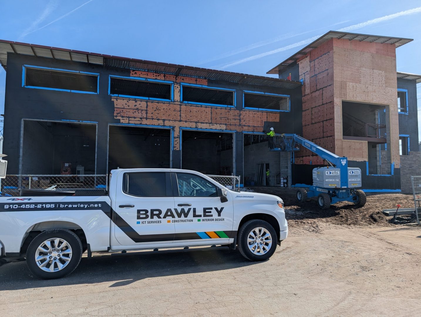 White pickup truck with Brawley written on it in front of a construction site